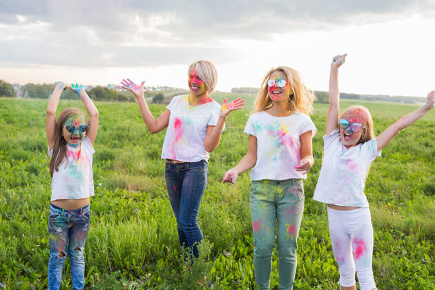 女人胡里节 友谊 节日和人的概念-跳跃快乐的妇女和女孩覆盖在油漆牛仔裤金发颜色