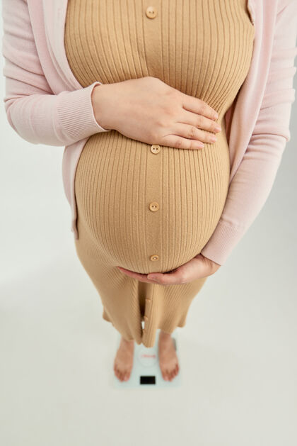女性孕妇站在秤上肚子产前形状