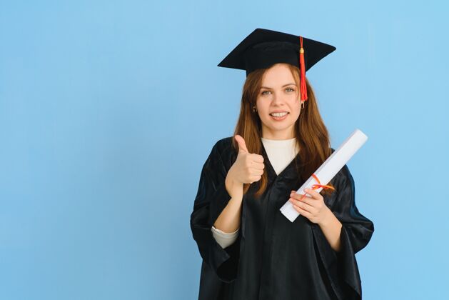 证书美丽的女人戴着毕业帽 穿着毕业礼袍 手持学位证书 看上去积极快乐 站着微笑 带着自信的微笑技术学院快乐