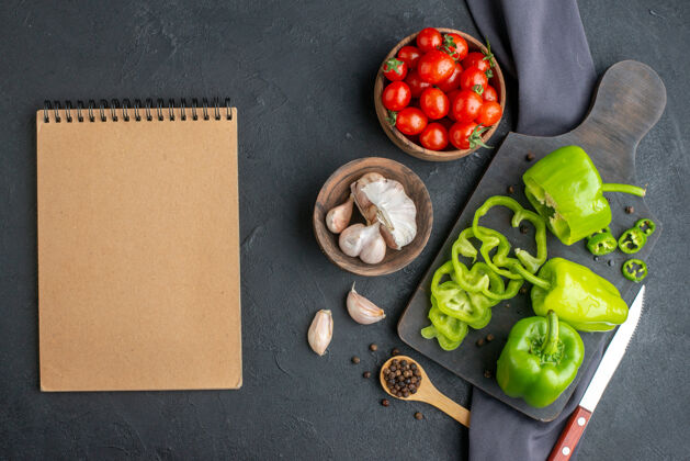 蔬菜上图：切好的青椒放在木制砧板上 西红柿放在碗里 西红柿放在深色毛巾上 黑色的表面水果青椒毛巾