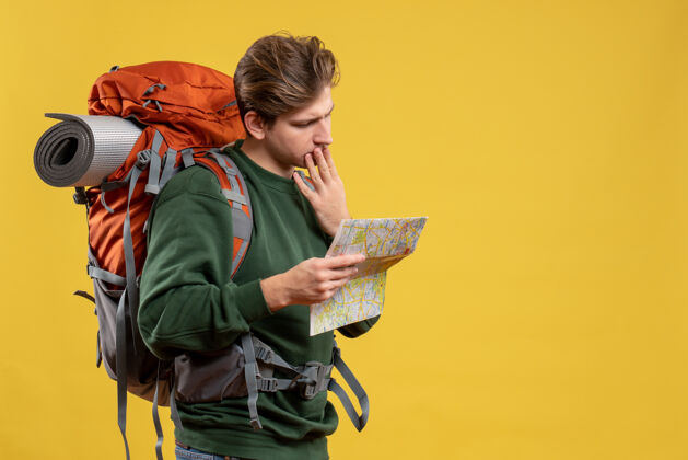 度假正面图年轻男子背着背包拿着地图黄色旅行旅游