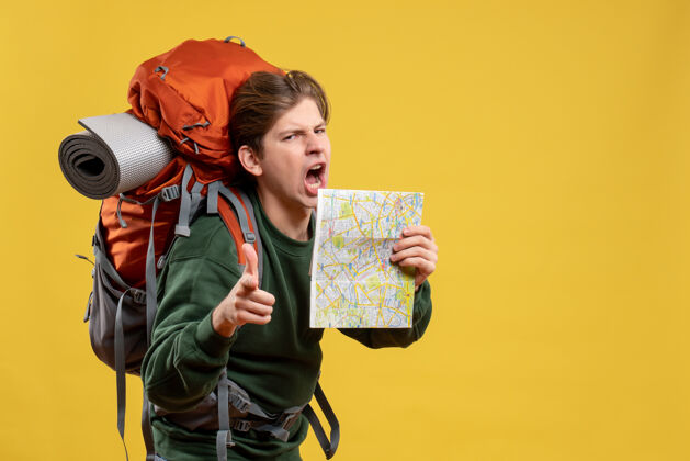 年轻男性正面图年轻男子背着背包拿着地图旅游成人度假