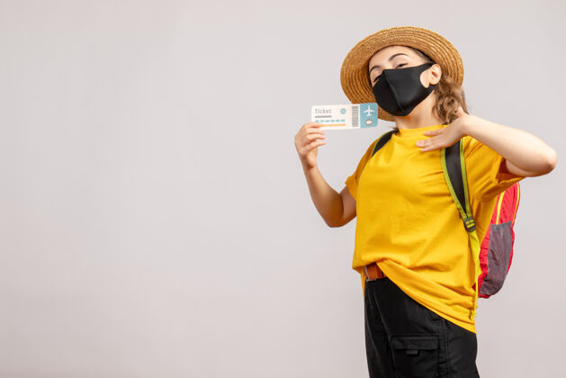 黑正面图年轻女子背着背包戴着黑色口罩拿着旅行票冒险年轻女人票