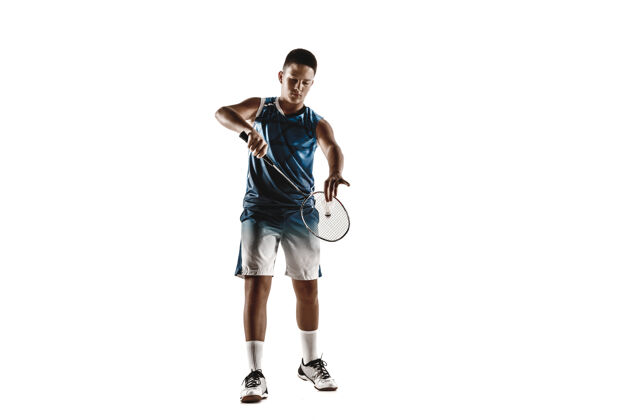 男孩小男孩打羽毛球孤立在白色工作室背景年轻的男模在运动服和运动鞋与球拍在行动 运动在游戏中运动的概念 运动 健康的生活方式年轻人活动羽毛球