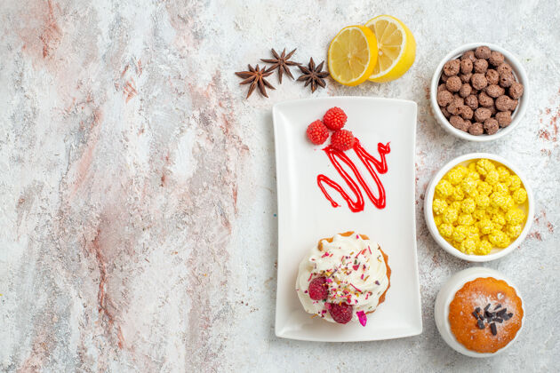 饼干俯瞰美味的奶油蛋糕与柠檬和糖果的白色背景饼干奶油蛋糕茶糖果蛋糕食物糖果