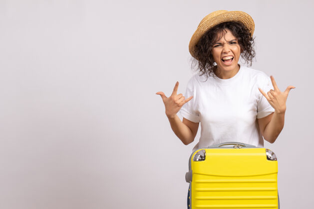 年轻女性正面图年轻女性带着黄色的袋子准备在白色背景上旅行度假航行飞行游客休息微笑人肖像