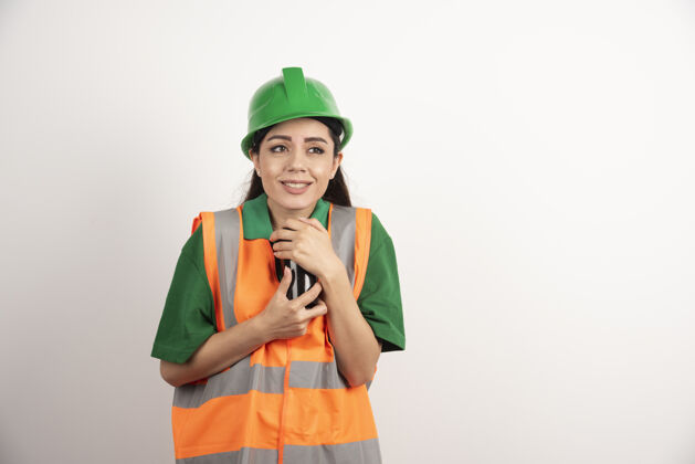 开发年轻的女建造师拿着黑色的杯子高质量的照片安全帽建设者女