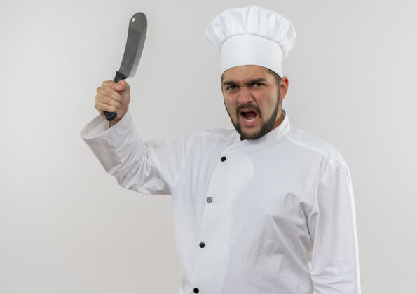 年轻愤怒的年轻男厨师穿着厨师制服举起切肉刀隔离在白墙上菜刀愤怒男性