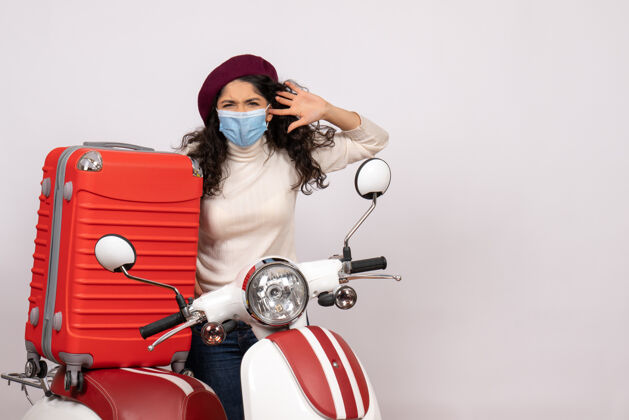 人前视图年轻女性戴着面罩骑在白色背景色covid上的自行车-车速病毒摩托车封面女郎速度年轻女性