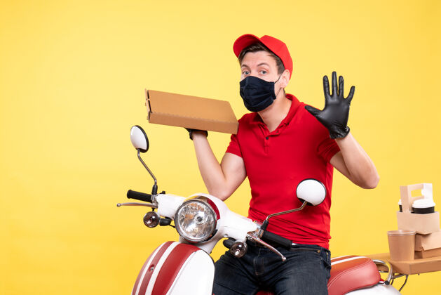 摩托车正面图戴着面具的男快递员拿着黄色的食品盒男快递工作自行车