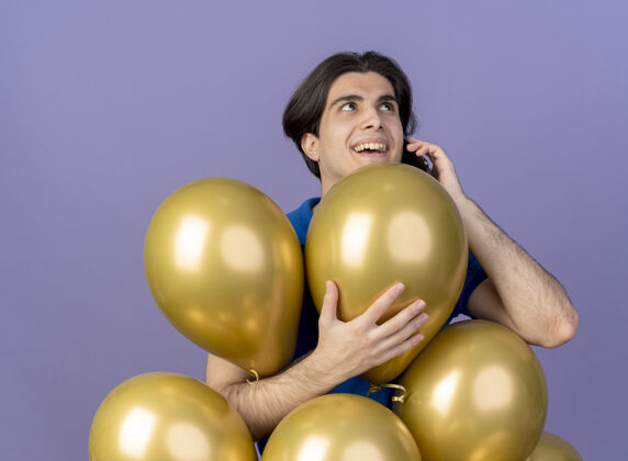 氦快乐英俊的白种人站在氦气球旁打电话紫色电话快乐