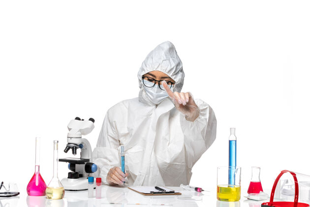 特殊正面图年轻的女化学家穿着特殊的防护服 拿着一个浅白色背景上的蓝色溶液烧瓶 科维德化学病毒实验室医学实验室医生