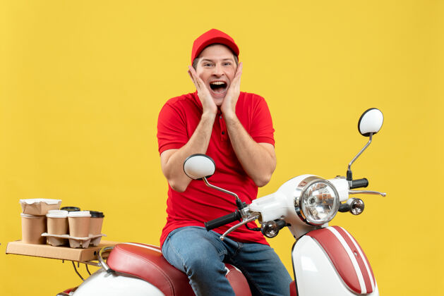 摩托车俯视图：身着红色上衣 头戴帽子 坐在黄色背景的踏板车上 微笑着传递着命令的年轻人红色轻便摩托车摩托车