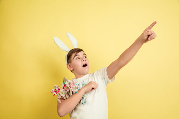 复活节复活节兔子男孩与明亮的情感黄色工作室墙上模型帅气时尚