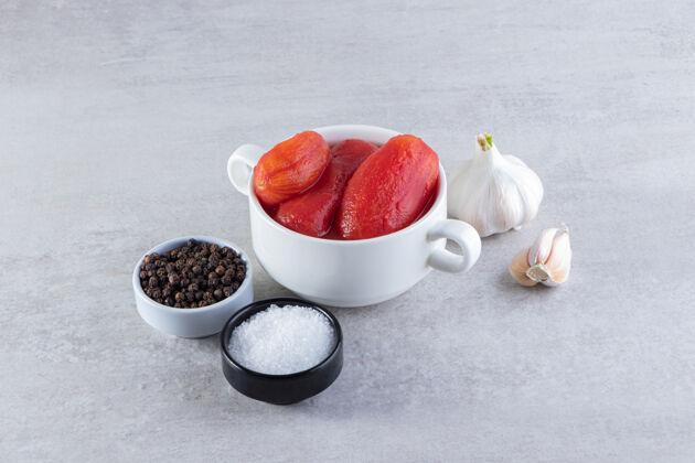盐把去皮的西红柿和新鲜的大蒜素和香料放在石桌上美味玉米番茄