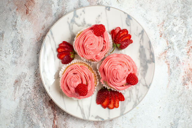 新鲜白色表面上有新鲜的红色草莓的粉色草莓蛋糕俯视图饼干美味饼干