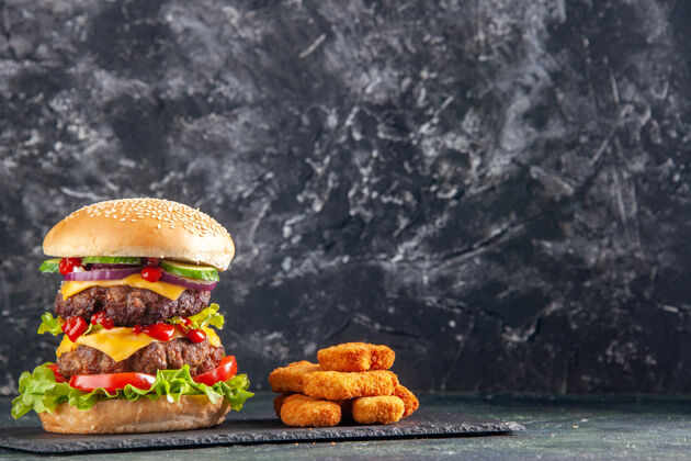 托盘美味的肉类三明治俯视图 深色托盘上有绿色的西红柿和黑色表面右侧的鸡块肉三明治鸡肉美味