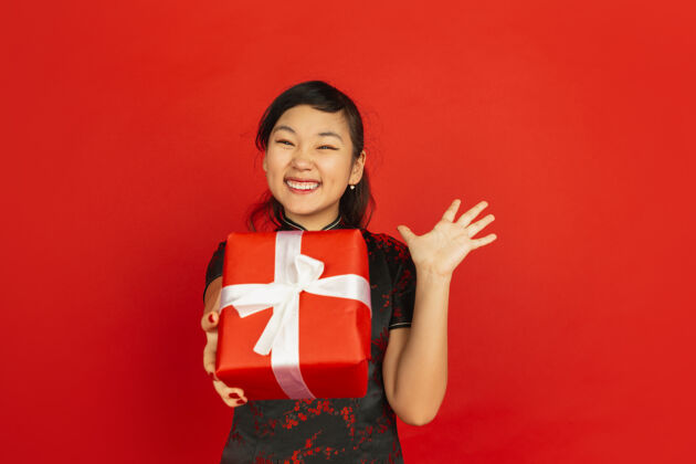 中国赠送礼品盒2020中国新年快乐红色背景上孤立的亚洲少女肖像穿着传统服装的女模特看起来很快乐庆祝 节日 情感复制空间美丽祝贺欢呼
