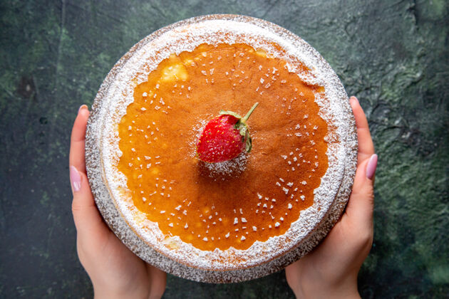 圆的俯瞰美味的蜂蜜蛋糕与糖粉圆木板黑暗的表面水果粉末板子