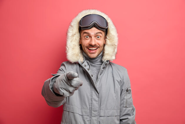 珊瑚快乐的冬季概念开朗的欧洲男人穿着外套 用愉快的表情直接表示看到眼前的东西很愉快满意雪运动装