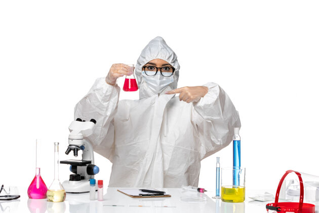 面具前视图穿着特殊防护服的女化学家拿着白色背景上的红色溶液-化学病毒实验室化学套装白色