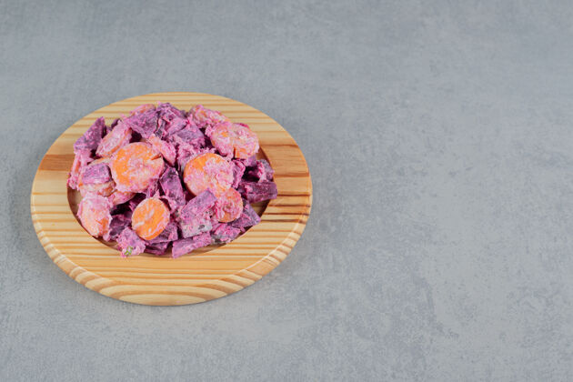传统紫色的甜菜根和胡萝卜沙拉放在木板上早午餐食物膳食