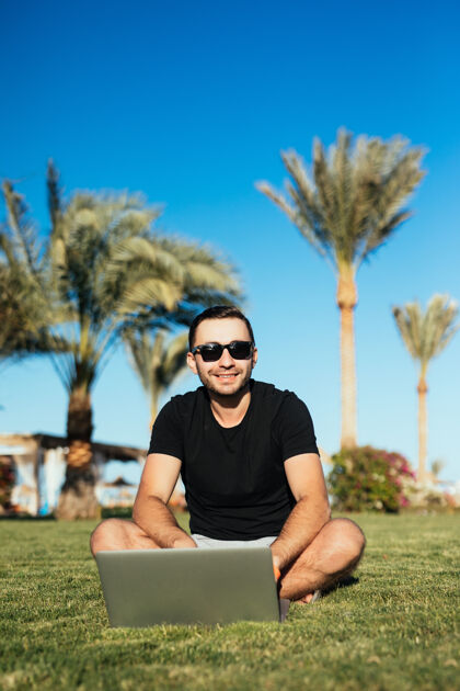 人帅哥坐在草地上用笔记本电脑笔记本电脑微笑女孩