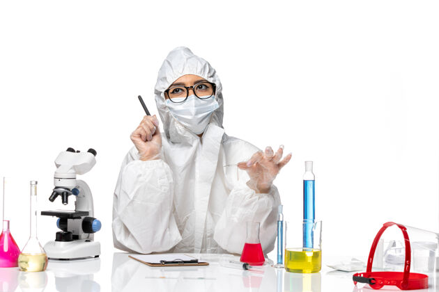 专业前视图穿着特殊防护服的女化学家在白色背景上写笔记病毒化学可维大流行健康流行病化学视图