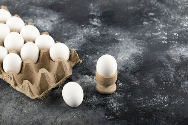 开放生鸡蛋放在大理石表面的鸡蛋盒里许多生的蛋白质