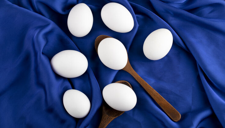 勺子一堆生鸡蛋 用木勺放在蓝色的棉布上木头烹饪天然