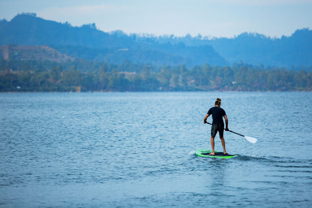 海洋一个男人在湖边骑冲浪板冲浪板热带神奇