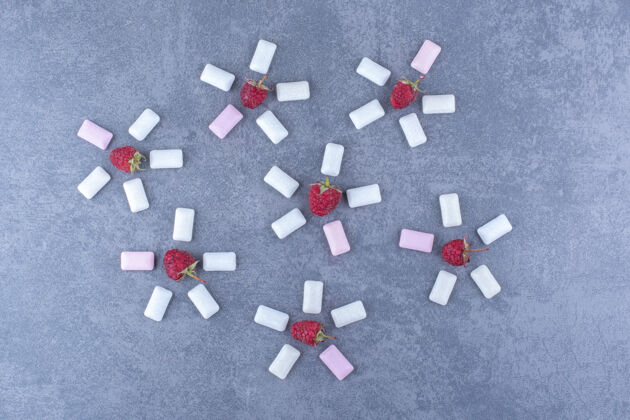 新鲜树莓和口香糖片在大理石表面装饰花形安排水果多汁覆盆子