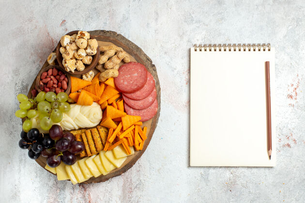 坚果俯视图不同的零食坚果cips葡萄奶酪和香肠白色背景坚果零食餐食品水果香肠顶部葡萄