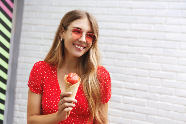 微笑快乐的女孩在户外吃着冰淇淋在城市里漫步 微笑着享受着街上的甜食街头冰淇淋休闲