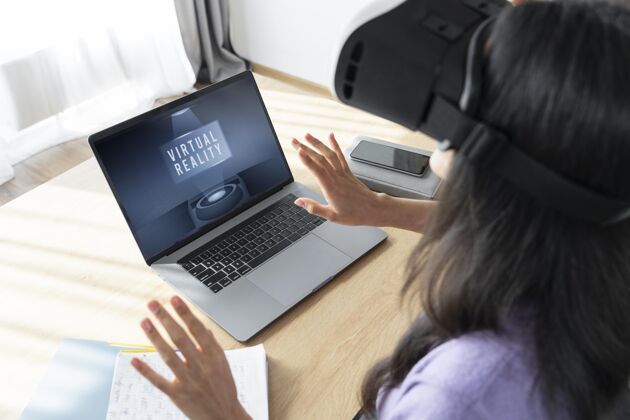 乐趣高角度的女人用虚拟现实耳机在家里用笔记本电脑虚拟现实眼镜虚拟现实耳机虚拟现实眼镜