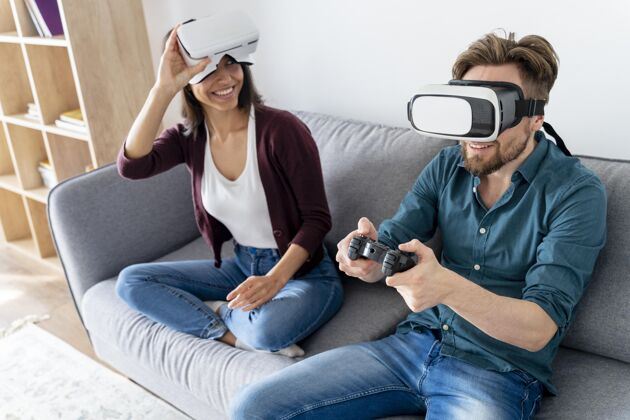 女人男人和女人坐在家里的沙发上 使用虚拟现实耳机水平家庭房子