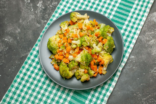 开销在灰色桌子上的绿色条状毛巾上健康蔬菜沙拉的俯视图餐厅沙拉蔬菜