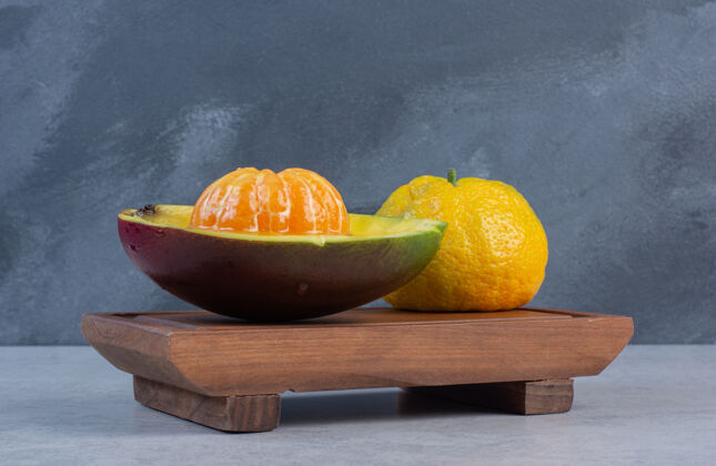 特写把整个橘子去皮 加果汁 放在木板上柑橘团体健康