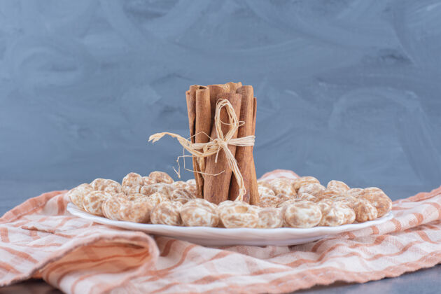 甜点肉桂棒和饼干放在毛巾上 大理石背景上美味毛巾垃圾食品