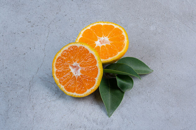 美味叶子和橘子片捆在一起放在大理石背景上柑橘水果橘子