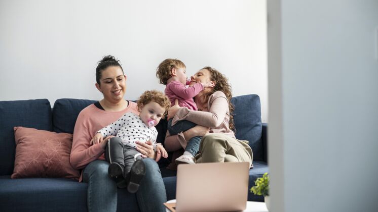 同性恋Lgbt妈妈在家和孩子坐在沙发上女同性恋家庭绘画父母