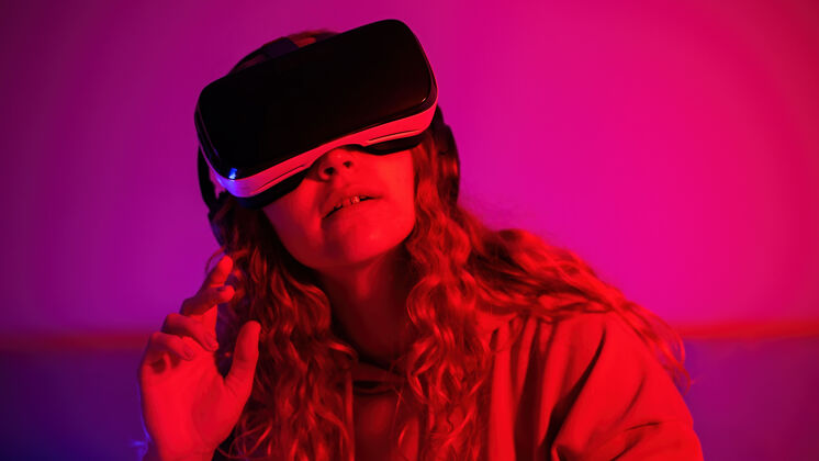 游戏戴着蓝色和红色虚拟现实眼镜的年轻女孩在房间里举起手来在家里娱乐虚拟现实视觉人