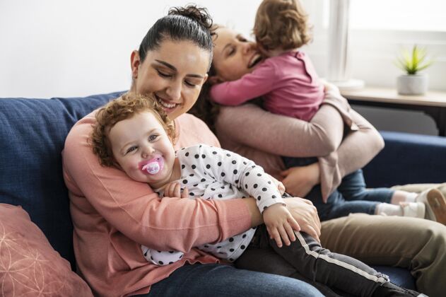 女人Lgbt妈妈在家和孩子坐在沙发上女同性恋家庭奶嘴同性恋者