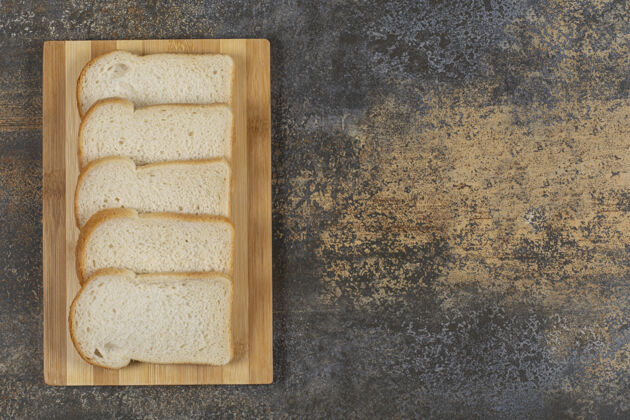 新鲜把自制面包片放在木板上早餐小麦切片