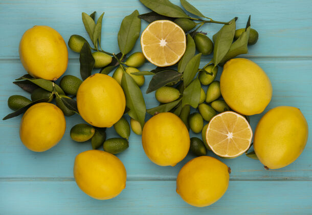 美味柑橘类水果的俯视图 如金盏花和柠檬 叶子孤立在蓝色的木质表面上美味素食叶子