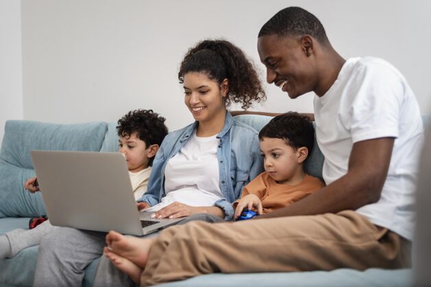 父亲快乐的黑人家庭在笔记本电脑上看电影家庭设备快乐的家庭