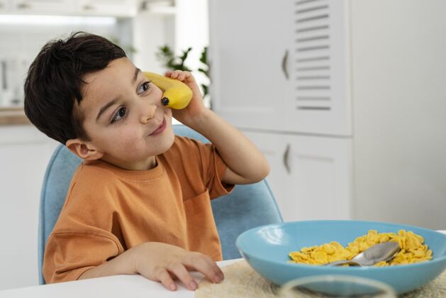 香蕉可爱的小男孩玩香蕉的画像早餐家庭餐桌