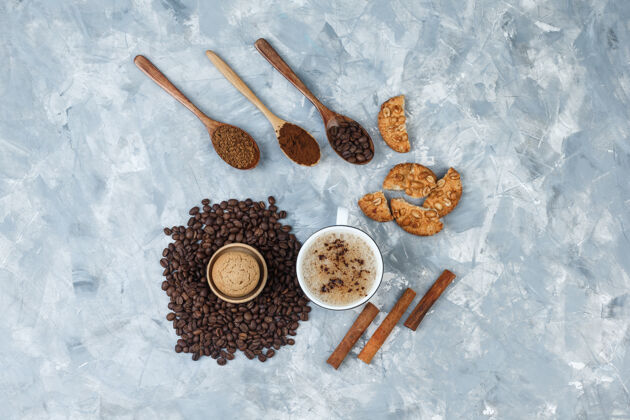 自然一些咖啡与饼干 咖啡豆 磨碎的咖啡 肉桂棒在一个肮脏的灰色背景杯 顶视图麻袋味道早晨