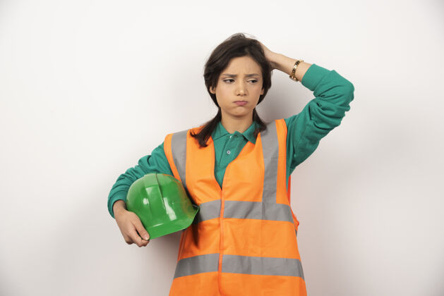 建筑工人心烦意乱的女工程师抓着头 拿着白色背景的头盔女性女士人