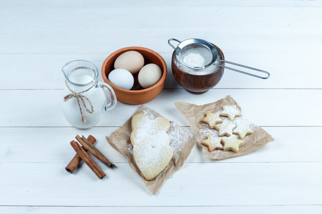 新常态一套饼干 肉桂棒 牛奶 糖粉和鸡蛋在一个木制背景碗高角度视图套装疾病防护